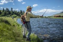 Man fishing on the bank of a river